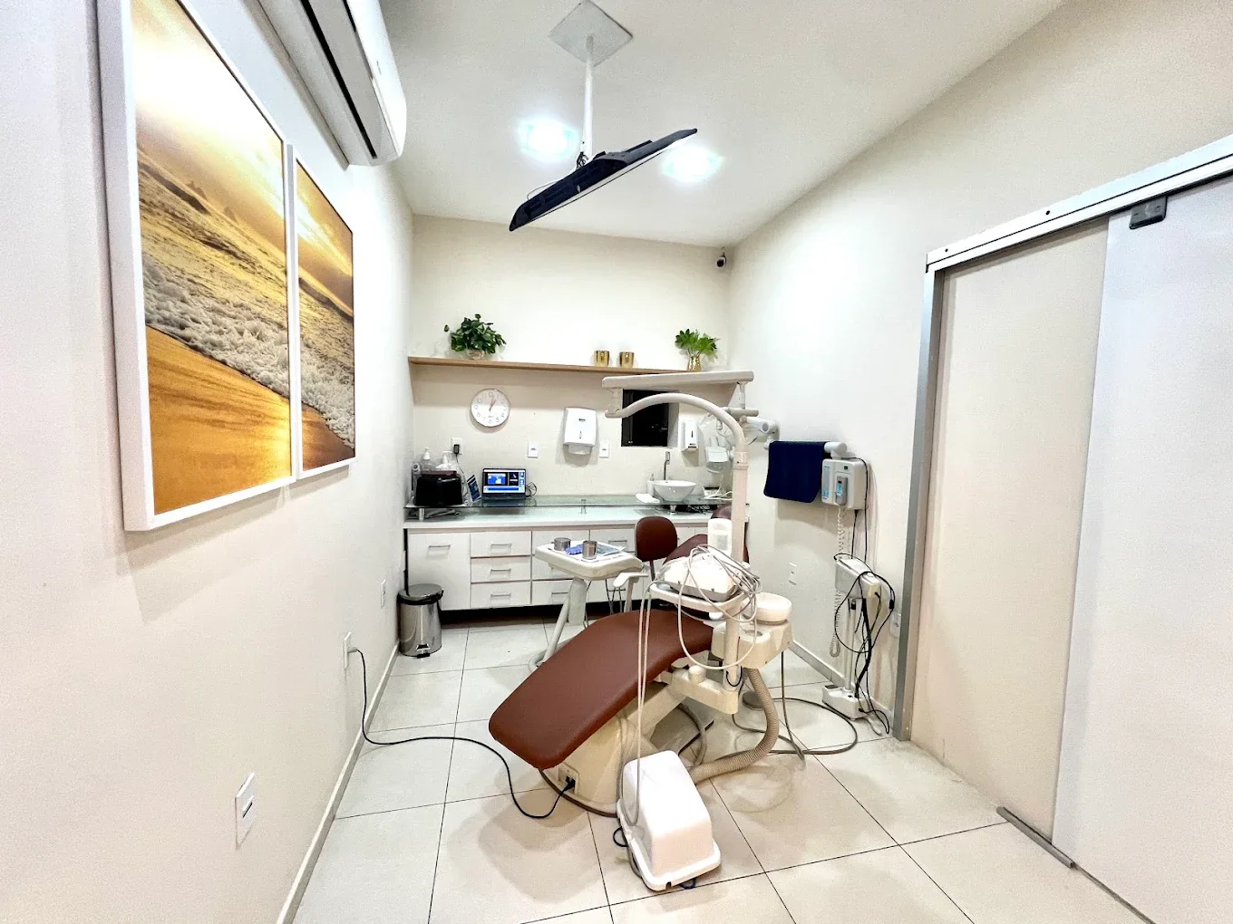 Consultório da Orthomais com cadeira odontológica, bancada de instrumentos e armário de apoio.
