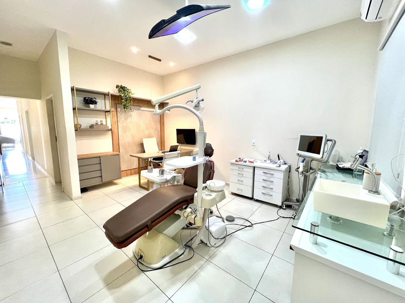 Consultório da Orthomais com cadeira odontológica e monitor de imagem digital montado em braço articulado.